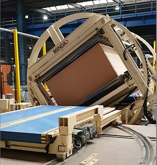 Stack turner in action, in the foreground pivoting car Stack turner in action: the product is clamped and turned, in the foreground the pivoting car can later takes over the turned product for removal.