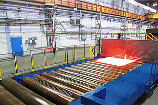 Side mobile loading carriage with roller conveyor and lift-out unit Side mobile loading carriage with roller conveyor and lift-out unit in a copper rolling mill: The roller conveyor is transported the incandescently rolled material from furnace until rolling mill.