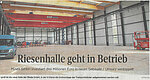Screenshot of a newspaper article with the title ‘Giant warehouse goes into operation’ and the image of a large, empty warehouse